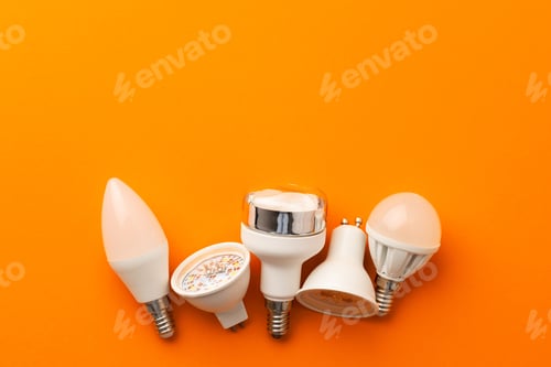 Preview: Light bulb on bright orange background top view
