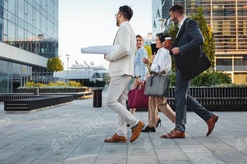 Preview: Group of business people walking outside in front of office buildings.
