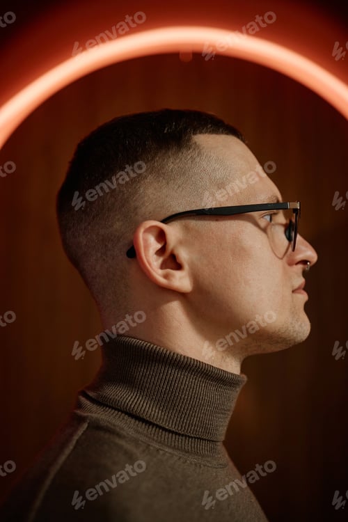 Preview: Caucasian Young Adult Man Wearing Glasses Posing in Profile under Neon Light
