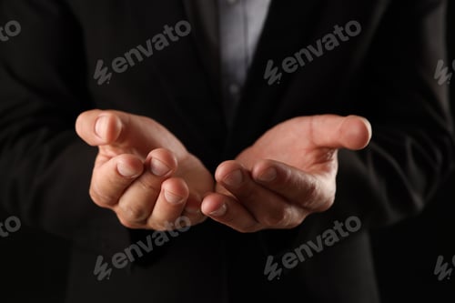 Preview: Man holding something on black background, closeup