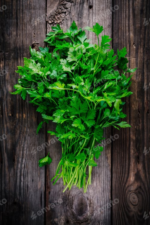 Preview: bunch of fresh organic parsley on a wooden rustic background.