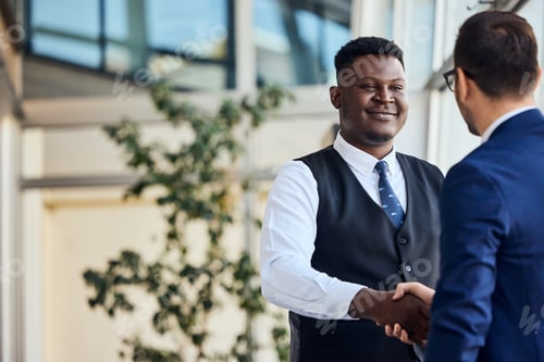 Preview: Two Business Professionals Shaking Hands in a Friendly Corporate Setting