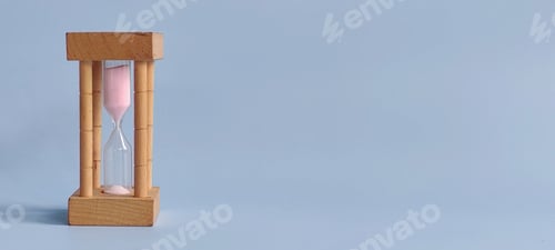 Preview: Sand Clock on Blue Background Representing Time, Patience, and the Passage of Moments