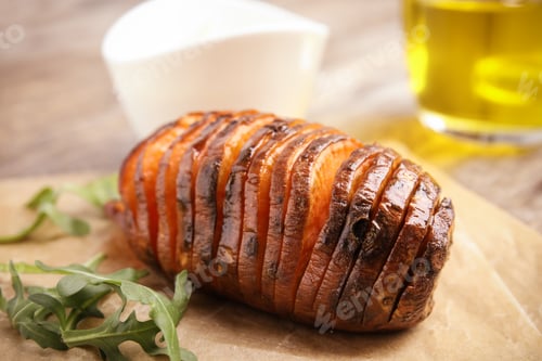 Preview: Delicious baked sweet potato and arugula on parchment, closeup