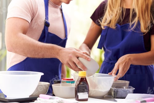 Preview: Close Up Of Male And Female Adult Students Measuring Ingredients In Cookery Class In Kitchen