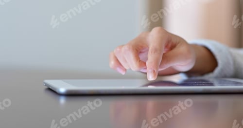 Preview: Woman finger touch on tablet computer at home