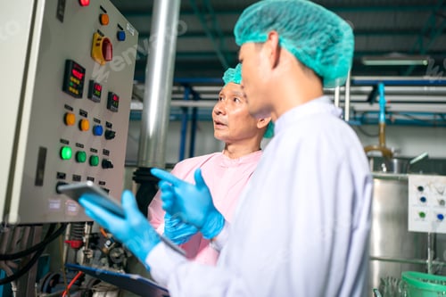 Preview: worker working in drink factory at conveyor belt with fruit juice glass bottled in production line