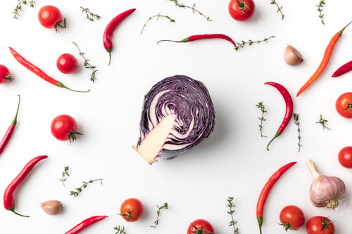 Preview: Top view of red cabbage among chili peppers and tomatoes isolated on white