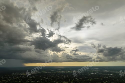 Preview: Dark stormy clouds forming on gloomy sky during heavy rainfall season over suburban town area