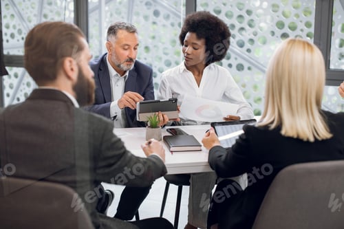 Preview: Multiracial businesspeople having meeting in boardroom at office. Bearded senior man, using tablet