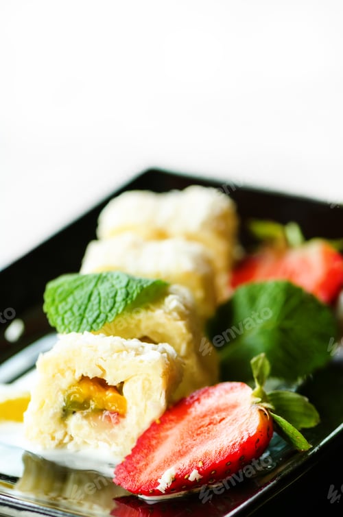 Preview: White sweet roll with kiwi, peaches, strawberries, mint. Serverd with almond peach and chocolate