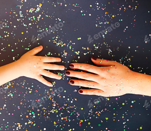 Preview: Hands of woman and kid in colorful confetti