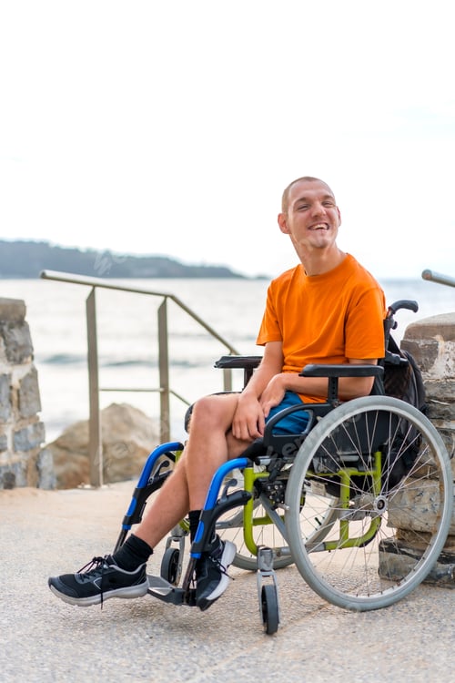 Preview: Portrait of pretty cheerful disabled person in wheelchair at the beach on summer vacation smiling