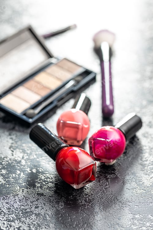 Preview: Colorful nail polish bottles on black table.
