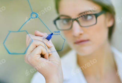 Preview: Shes onto a new path. Closeup shot of a scientist writing formulas on a glass wall.