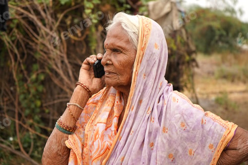 Preview: Senior Indian rural woman talking on phone