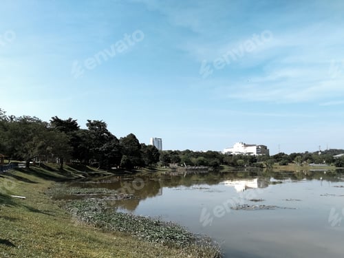 Visualização: lago com reflexos em um dia ensolarado perto da cidade