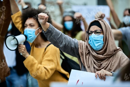 Preview: Muslim woman wearing protective face mask while participating in anti-racism protest.