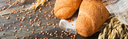 Preview: Bread wholemeal oat and buckwheat flour with spikes on old wooden background. Selective focus