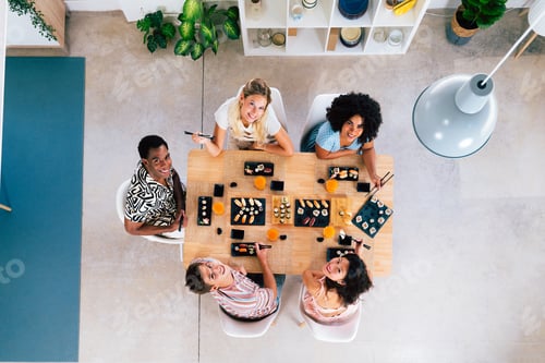 Preview: Multiethnic group of young friends meeting at home and eating sushi