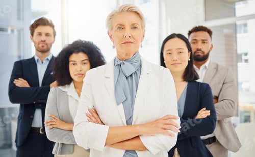 Preview: Portrait of a serious mature caucasian businesswoman standing with her arms crossed in an office wi