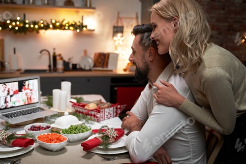 Preview: Loving couple during video conversation at the Christmas table
