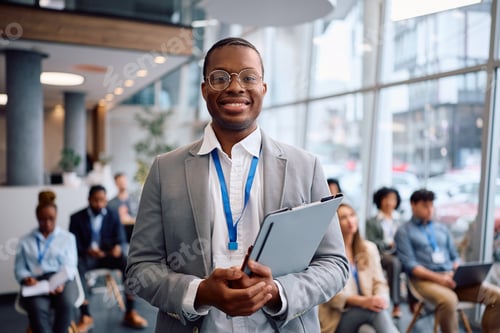 Preview: Happy black business seminar presenter in board room looking at camera.