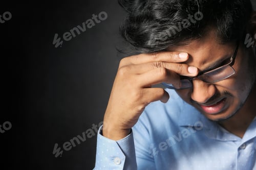 Preview: Young man frustrated and suffering headache, close up