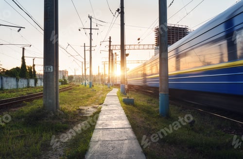 Preview: High speed passenger train in motion on railroad track at sunset