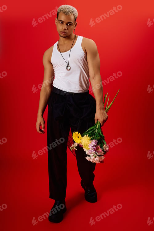 Preview: Bold fashion statement with a young man in a vibrant red studio setting