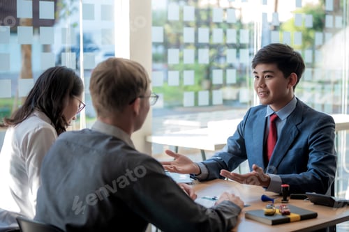 Preview: Asian business people in smart casual wear at meeting discussing new business project to his partner