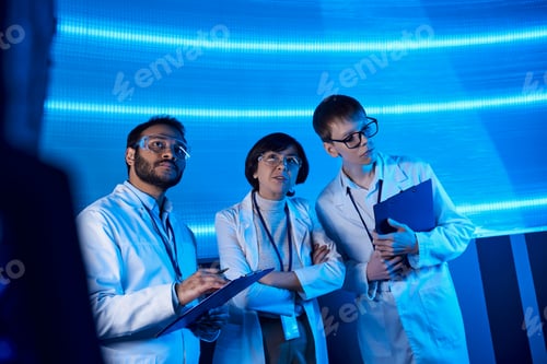 Preview: forward-thinking multiethnic scientists with clipboards collaborate in neon-lit innovation hub