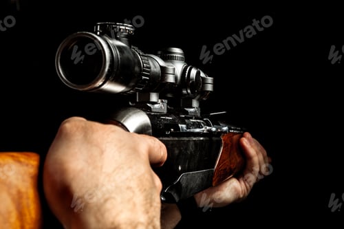 Preview: Male hands holding hunting rifle on black background
