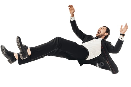 Preview: scared young businessman in suit falling isolated on white