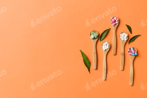 Preview: Top view Variety of vitamin and mineral pills in wooden spoon