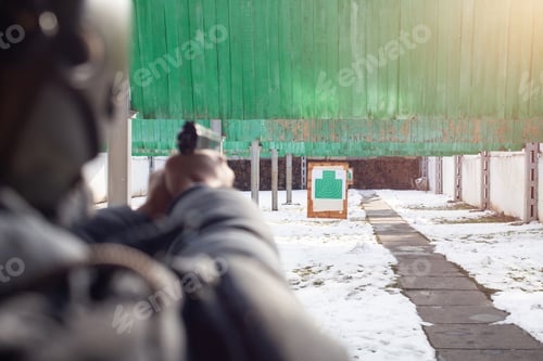 Preview: A man is aiming at the target. Tyre outside the door. Winter. Sports entertainment, firearms