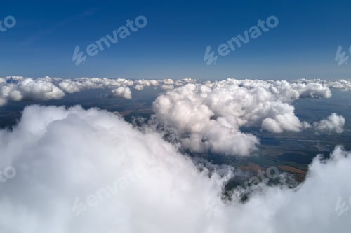 Preview: Aerial view from airplane window at high altitude of earth covered with puffy cumulus