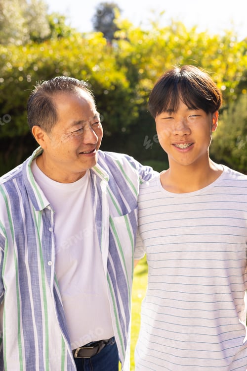 Preview: asian father and son smiling together, enjoying quality time outdoors in garden