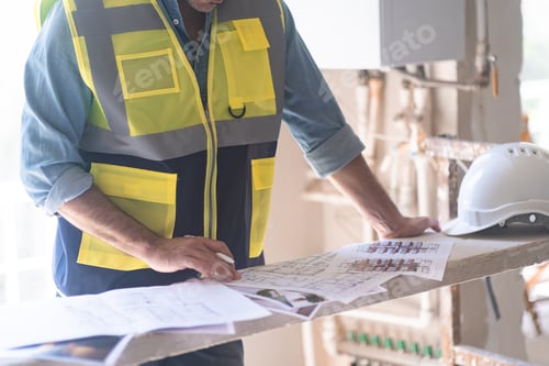 Preview: Engineer in vest studying project documentation getting ready for reconstruction