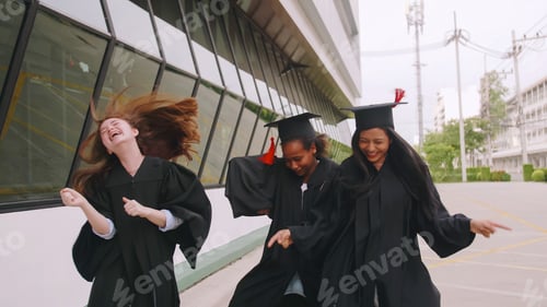 Preview: Group of friends having fun celebrating their graduation by dancing together.