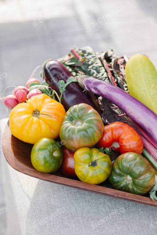 Preview: Wooden bowl with fresh vegetables standing on a table.