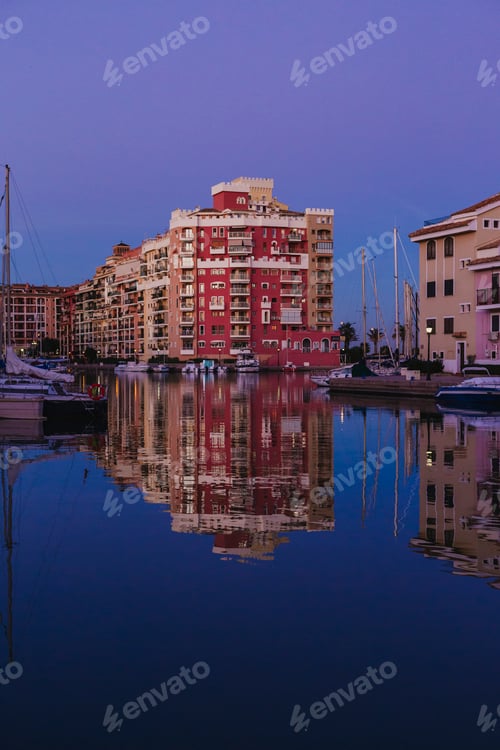 Preview: reflection of the houses in the port of Valencia, Spain. Boats at the dock. sunset, blue hour