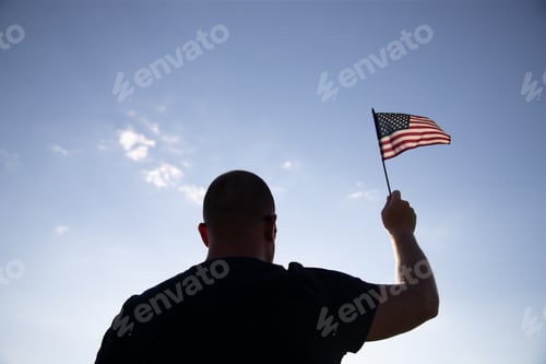 Preview: Man holding a waving american USA flag.
