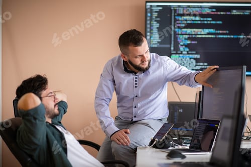 Preview: Programmers engrossed in deep collaboration, diligently working together to solve complex problems