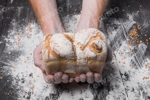 Preview: Bakery concept background. Hands hold bread loaf