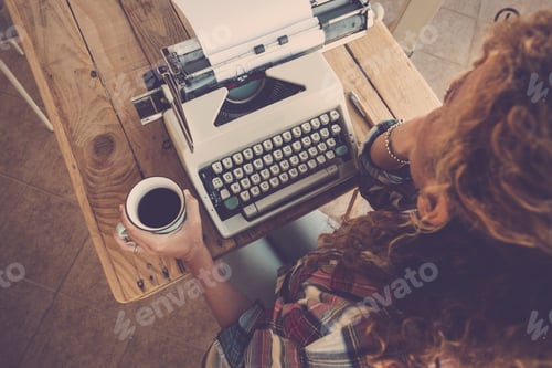 Preview: Above view of curly woman thinking and taking coffee with old typewriter on the table