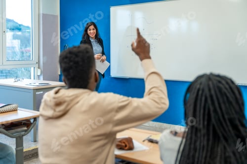 Visualização: Estudantes universitários levantando a mão na sala de aula durante a aula