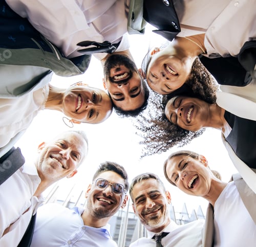 Preview: Diverse and cheerful businesspeople standing in a circle in the street. Low angle view of a happy