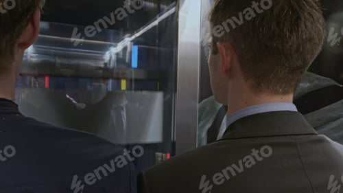 Preview: Team of start up businesspeople entering modern elevator and discussing corporate meeting. Stock
