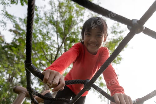 Preview: summer, childhood, leisure and people concept happy little girl on children playground climbing